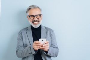 Laughing middle-aged man with smartphone